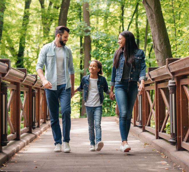 Family walking on a bridge in a forest